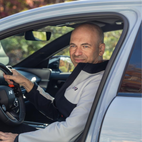Manfred Harrer sitting in a car and smiling