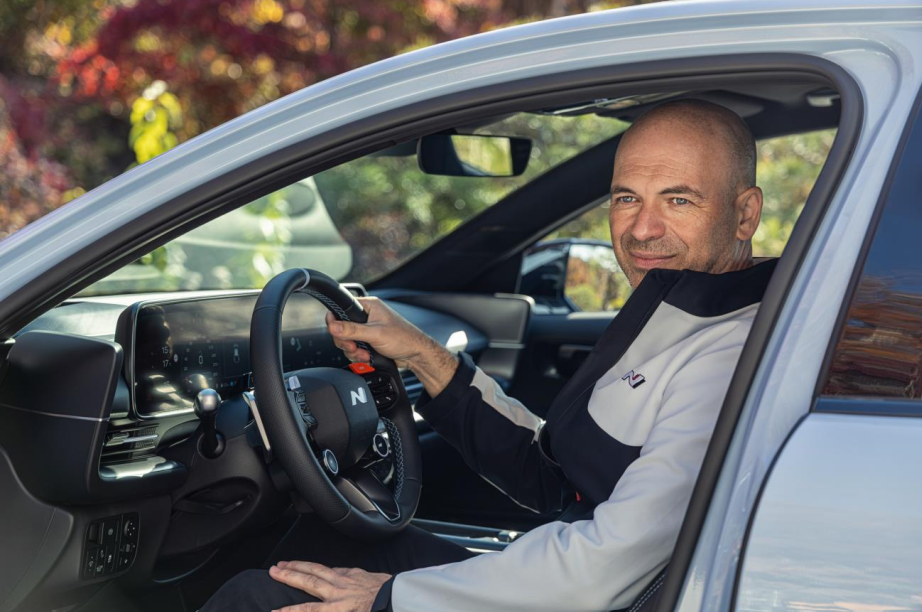 Manfred Harrer sitting in a car and smiling