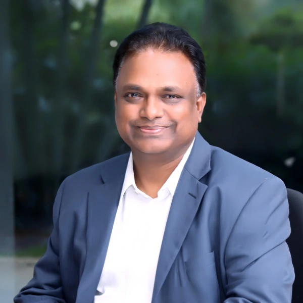 Velusamy smiling into the camera.